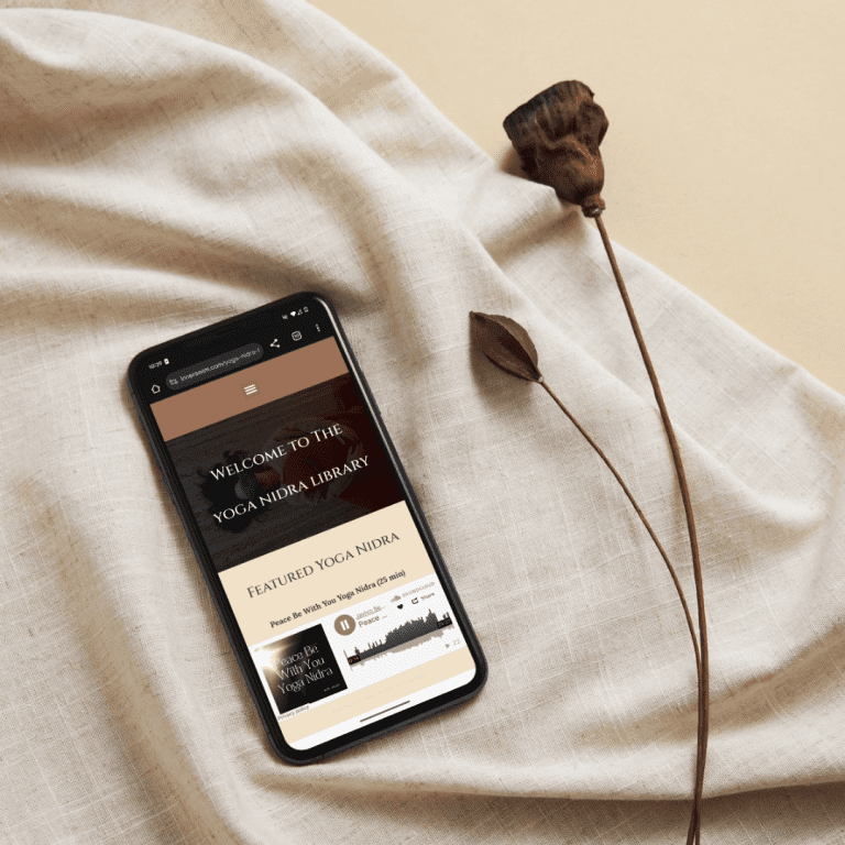Phone displaying the Yoga Nidra Library on soft linen fabric
